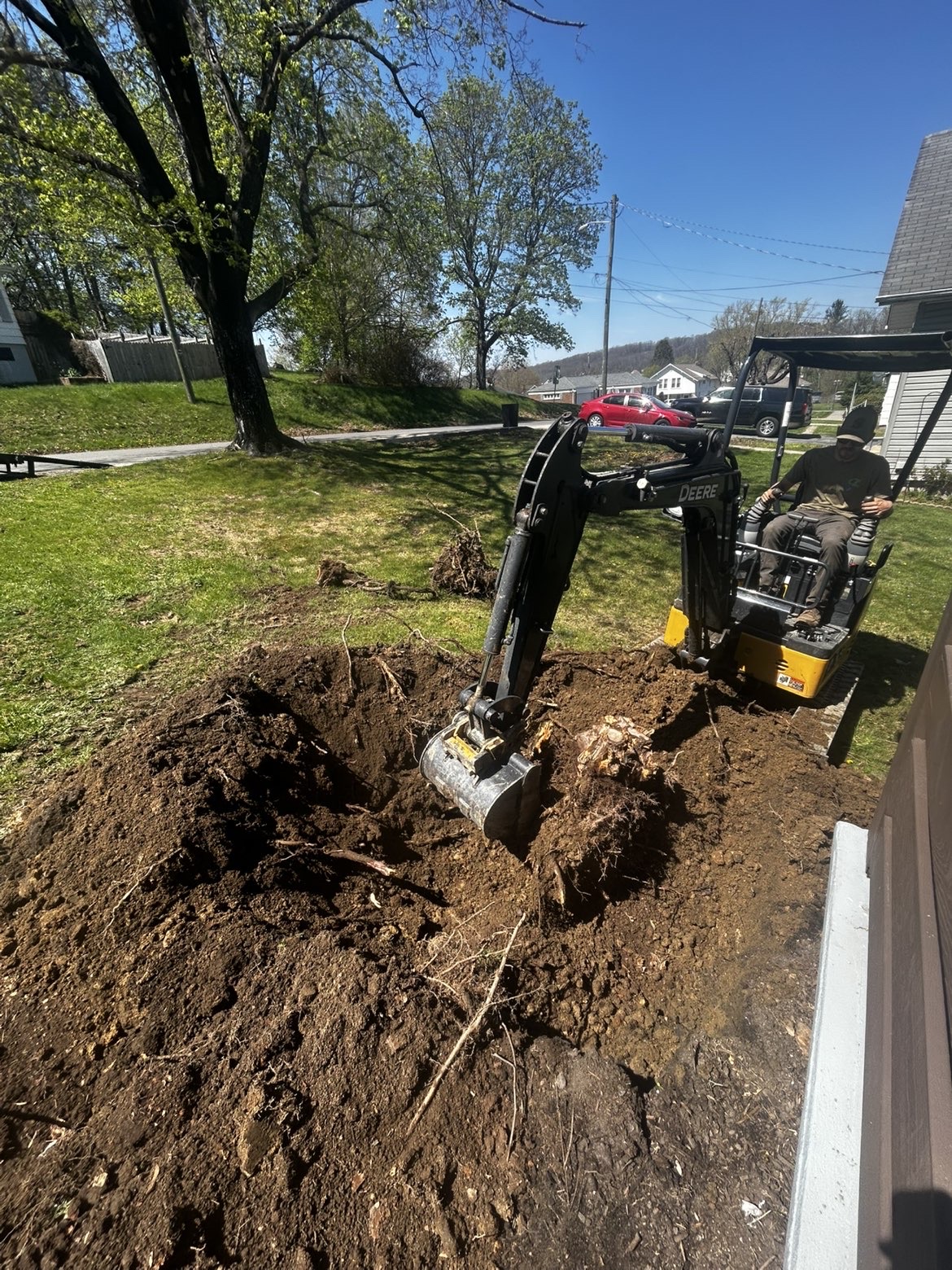 Mini excavator performing stump and dirt work